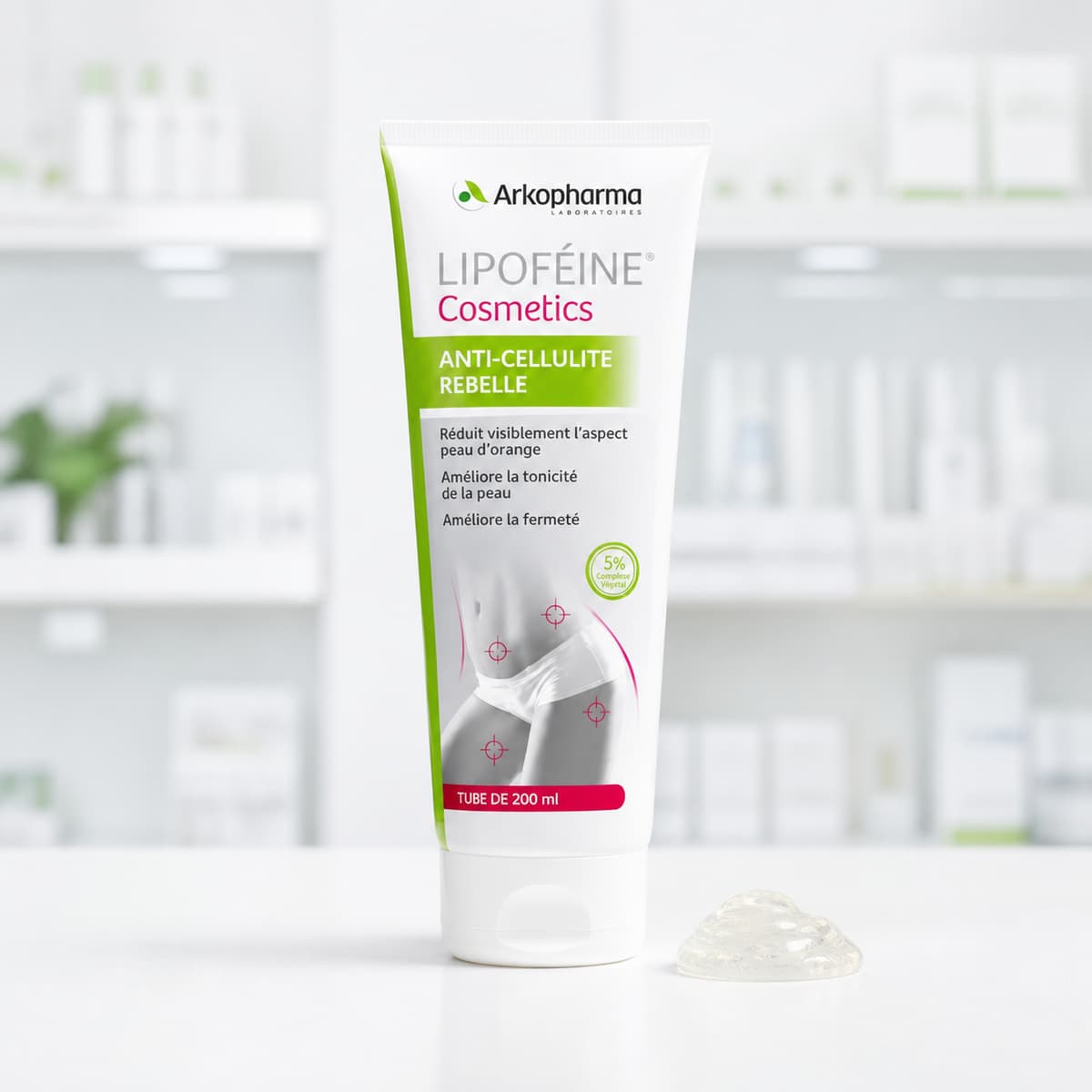 Tube de soin anti-cellulite Arkopharma Lipofeine posé sur un comptoir blanc à côté d'une noisette de gel translucide.